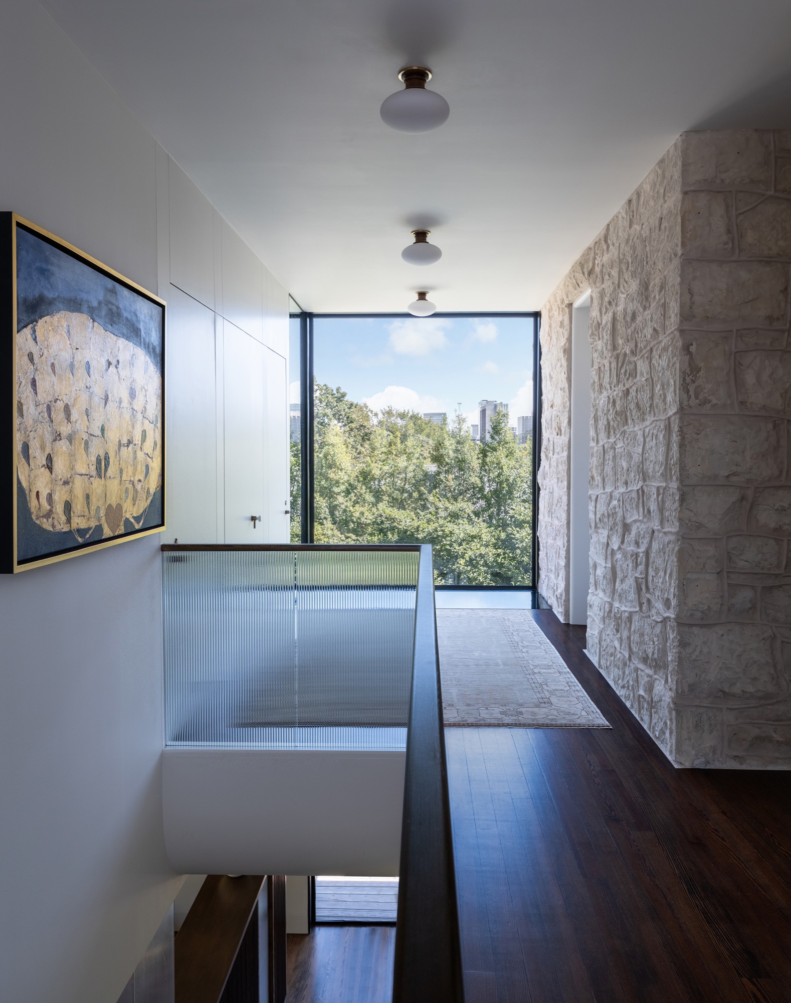 Victorian House stair hall connector with stone wall and ribbed glass in Austin, Texas